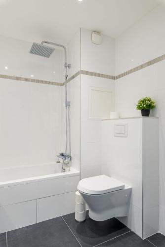 une salle de bain blanche avec toilettes et baignoire dans l'établissement T2 Part Dieu, à Lyon
