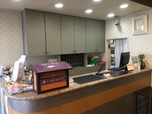 a kitchen with a counter with a counter top with a computer at Hotel Tajimi Hills Riverside in Tajimi
