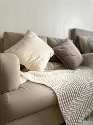 a couch with pillows and a blanket on it at Eden Living - Cebu in Lapu Lapu City