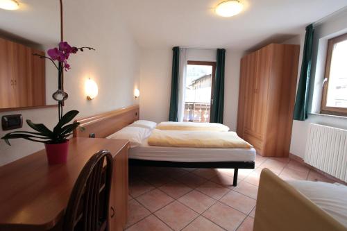 リヴィーニョにあるHotel Miramontiのベッドルーム1室(ベッド2台、テーブル、デスク付)