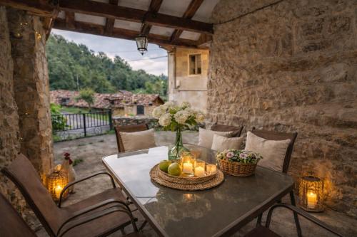a table with a vase of fruit and candles on it at Casa Rural La Carrozal Senda del Oso in Orelleiru