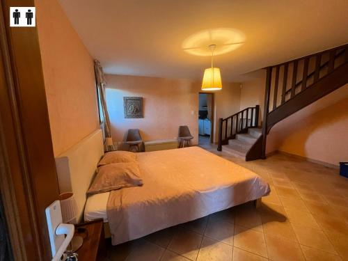 a bedroom with a bed and a staircase in it at Gîte au Ventoux in Villes-sur-Auzon