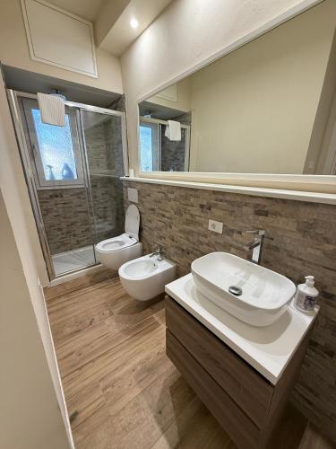 a bathroom with a sink and a toilet and a mirror at Casa Lorà in Pistoia