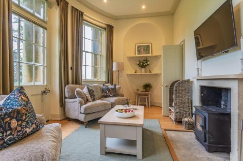 een woonkamer met een bank en een open haard bij Bath Lodge in Tormarton