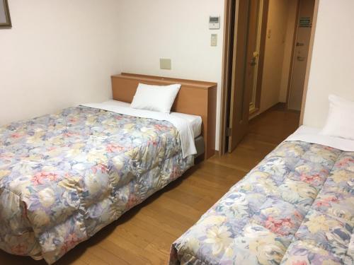 a hotel room with two beds in a room at Hotel Tajimi Hills Myroom in Tajimi
