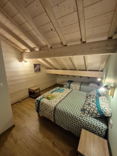 a bedroom with a bed in a room with wooden ceilings at Maison Gite Le Randonneur in La Bresse
