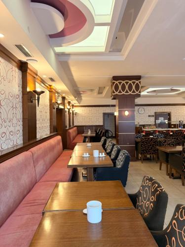 a restaurant with couches and tables in a room at Airport Global Hotel in Mörfelden-Walldorf