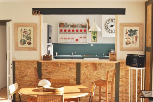 une cuisine avec un comptoir, une table et des chaises dans l'établissement Maison d'hôtes Stella Maris aux Ateliers de Piguet, à Carantec
