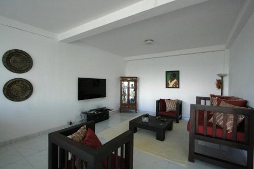 ヌワラエリヤにあるSingha Sanasa Luxury Homestayのリビングルーム(ソファ、壁掛けテレビ付)