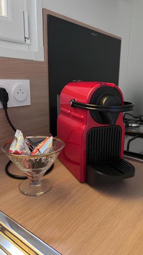 un grille-pain rouge posé sur un comptoir à côté d'un bol dans l'établissement Studiotel premium 2 personnes, à Pamiers