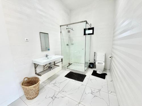 a bathroom with a glass shower and a sink at Amuji Accommodation and Apartments in Vilanculos