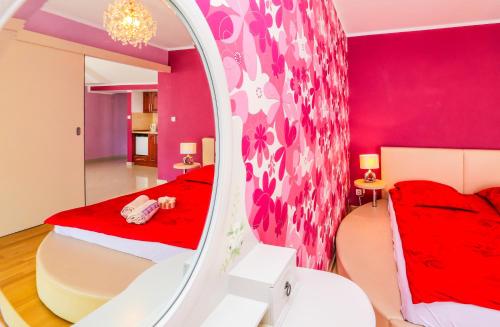 弗瓦迪斯瓦沃沃的住宿－Apartament Margarites，一间卧室配有红色的床和镜子