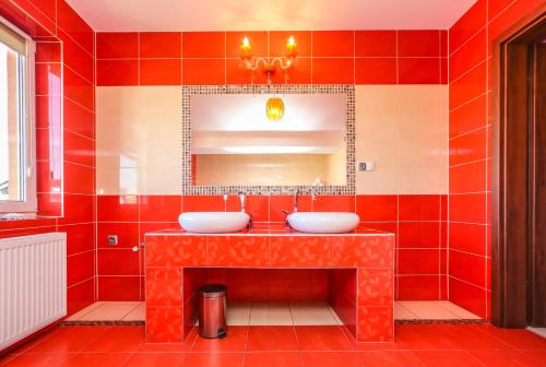 ブワディスワボボにあるApartament Margaritesの赤いタイル張りのバスルーム(シンク2台、鏡付)