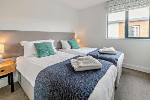 a bedroom with two beds with towels on them at 2 Bed in Woolacombe oc-s29469 in Woolacombe