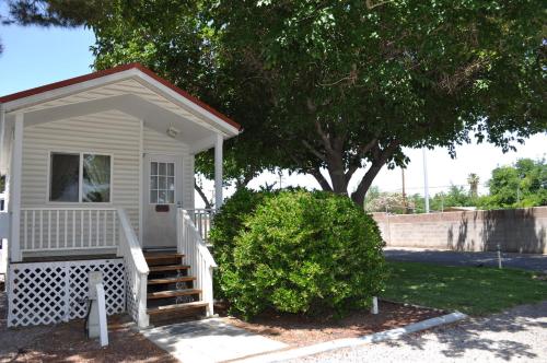 a small white house with stairs and a tree at Las Vegas Camping Resort Cabin 5 in Las Vegas