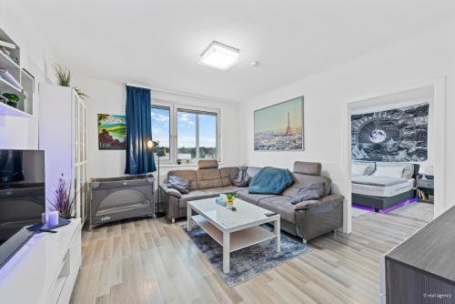 ein Wohnzimmer mit Sofa und Tisch in der Unterkunft Big 1 Bedroom Apartment near Airport & City Center in Schwechat