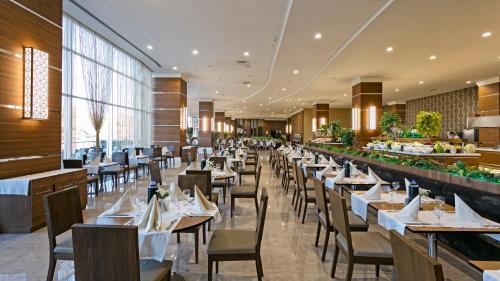 a dining room with tables and chairs in a restaurant at Grannos Thermal Hotel & Convention Center in Haymana