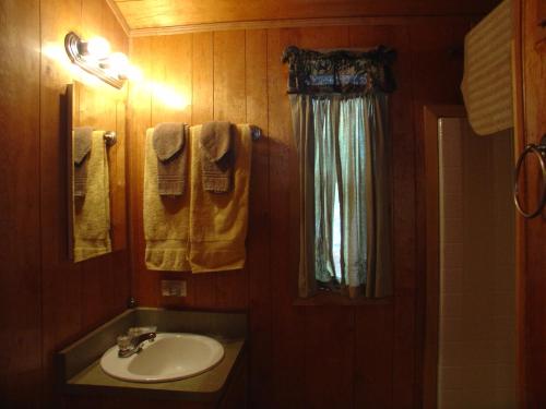 ein Bad mit einem Waschbecken, einem Fenster und Handtüchern in der Unterkunft Idyllwild Camping Resort Cabin in Idyllwild