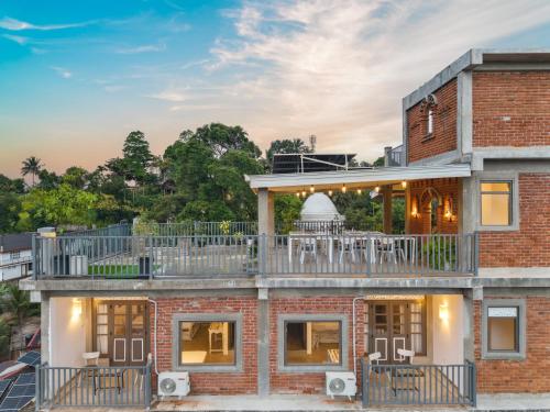 een bakstenen huis met een balkon erop bij Earthbound Residence in Kandy