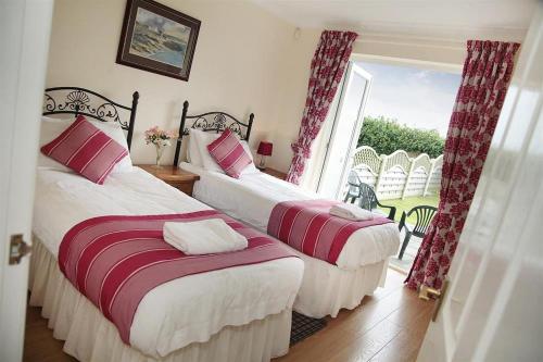 twee bedden in een kamer met een raam bij 4 Bed in Port Eynon oc-hh9901 in Port-Eynon