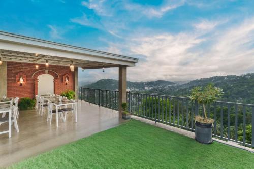 een terras met een tafel en stoelen op een balkon bij Earthbound Residence in Kandy