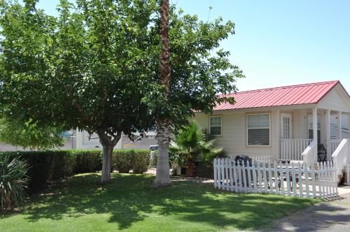 a house with a white fence and a tree at Las Vegas Camping Resort Cabin 2 in Las Vegas