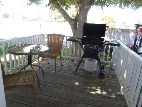 a grill on a deck with a table and chairs at Las Vegas Camping Resort Cabin 4 in Las Vegas