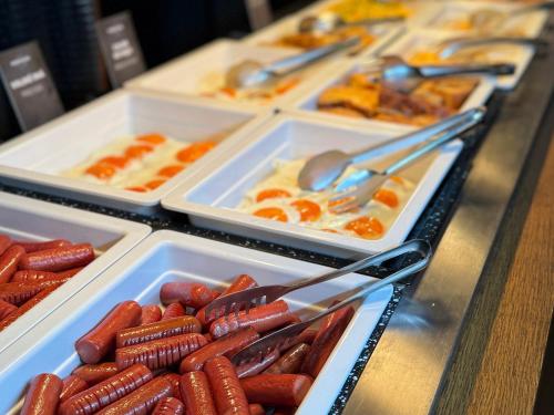 un buffet avec des plateaux de hot-dogs et autres aliments dans l'établissement Penzión & Wellness MERIDIANA Bojnice rezort, à Bojnice