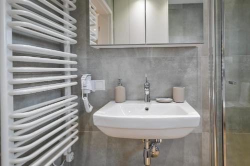 un bagno con un lavandino bianco e uno specchio di Sun & Garden House a Oświęcim