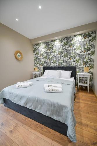 a bedroom with a large bed with two towels on it at Sun & Garden House in Oświęcim