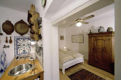 ein Bad mit einem Waschbecken und ein Bett in einem Zimmer in der Unterkunft Siebenbrüderhof in Weiden am See