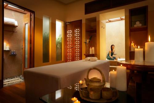 a woman in a room with a bed and candles at PULSE GRANDE Hotel Putrajaya in Putrajaya
