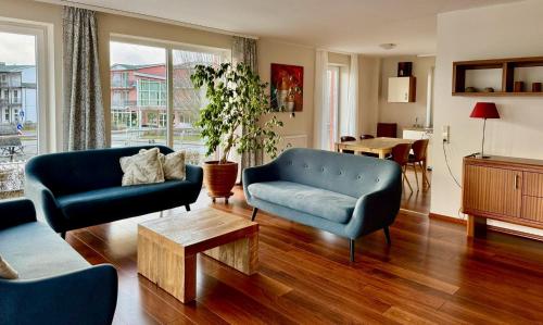 een woonkamer met een bank, stoelen en een tafel bij Appartement Werft & Meer in Lauterbach