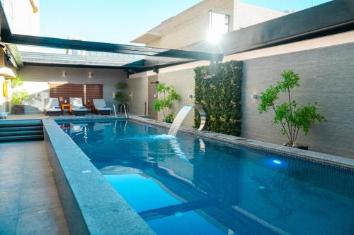 a swimming pool with a waterfall in a house at Lijam Hotel in Amman