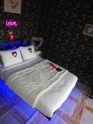 a bed in a room with hearts on the pillows at Cabalove in Quissac