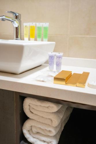 a bathroom with a sink and towels on a counter at Lijam Hotel in Amman
