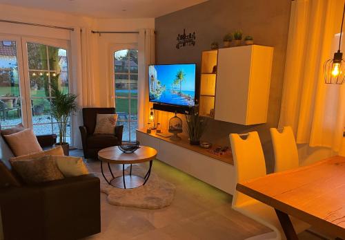 a living room with a television and a table at Saras Weinchalet in Guntersblum