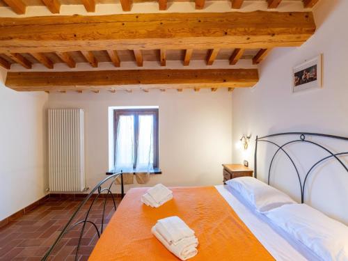 a bedroom with a bed with two towels on it at Apartment in a farmhouse with 2 swimming pools in Cagli