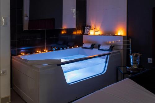 een bad in een kamer met verlichting bij NAR Royalton Accommodation in Niš