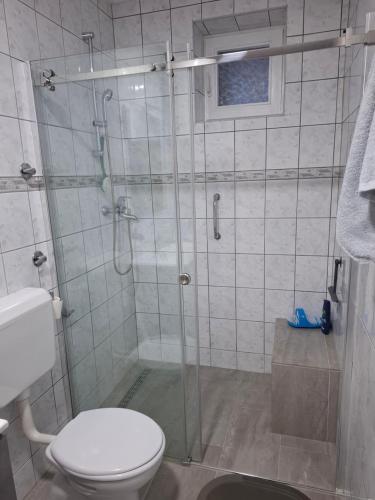 a bathroom with a glass shower with a toilet at Studio apartman KONAK in Kupres