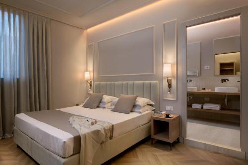 a bedroom with a large bed and a bathroom at Hotel San Gregorio in Pienza