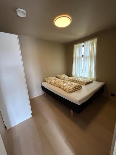 a small bedroom with a bed with a window at Sentral leilighet in Egersund