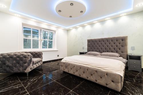 a bedroom with a large bed and a tufted headboard at NEU! HeideVilla - Private Pool, Sauna & Mini Golf in Asendorf