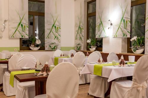 a dining room with white tables and chairs at Hotel Am Markt in Ehrenfriedersdorf