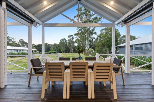 ein Esszimmer mit Tisch und Stühlen auf einer Terrasse in der Unterkunft Homestead on Fennell - Fresh Eggs, Farm & BBQ Fun in Toronto