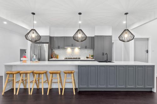 eine Küche mit einer Theke mit Barhockern in der Unterkunft Homestead on Fennell - Fresh Eggs, Farm & BBQ Fun in Toronto