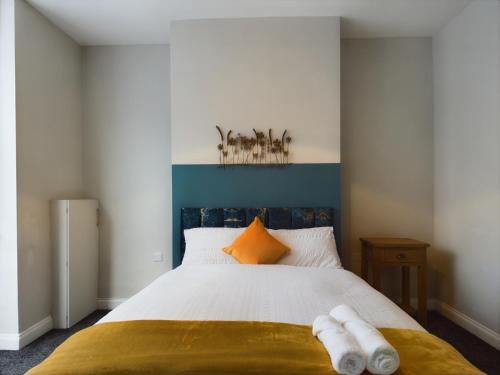 a bedroom with a bed with a blue headboard at Pottery House - Stoke on Trent -Free parking- Central Location - Sleep 8 in Stoke on Trent