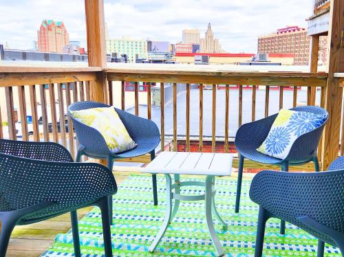 three chairs and a table on a balcony with a view at Jennifer's Chic Downtown City Views Private Deck in Providence