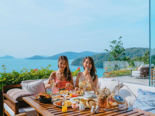 twee vrouwen aan een tafel met eten bij V Villas Phuket - MGallery Collection in Panwa Beach