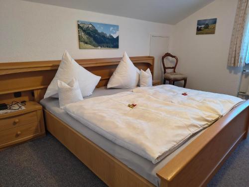a bedroom with a large bed with white sheets and pillows at Gästehaus Finkel in Maderhalm
